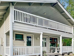 A two-story house with a porch, a covered front entrance, and a visible window.