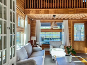 A cozy cabin interior with a sofa, a table, and a potted plant. - Villa rauha by Interhome (Soini)