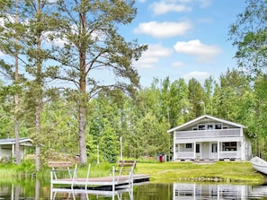 A lakeside cabin with a dock, surrounded by trees and a clear sky. - Villa rauha by Interhome (Soini)