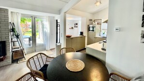 A modern kitchen with a dining area, a built-in oven, and a small island.