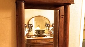 A tall wooden cabinet with a mirror, featuring a top shelf with various items. - 3-bedroom vacation home - perfect for Tulip Time or Hope College Events! (Holland)