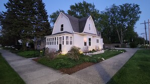 A two-story house with a gabled roof, a front porch, and a well-maintained lawn. - 3-bedroom vacation home - perfect for Tulip Time or Hope College Events! (Holland)
