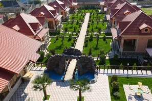 A resort with multiple red-roofed buildings, a central pathway, and a small pool area. - Panorama Hotel Oghuz (Oguz)