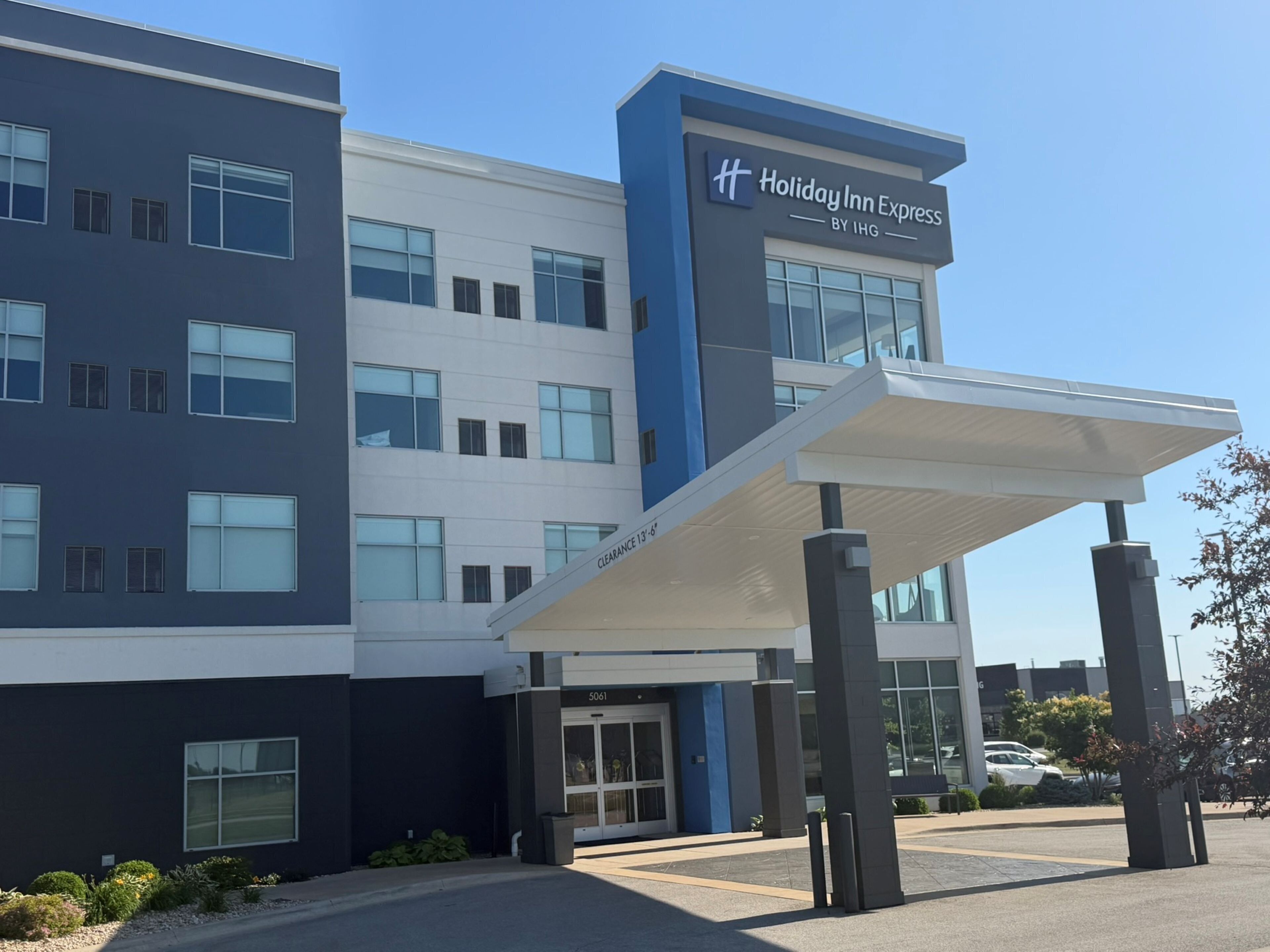 Un edificio de Holiday Inn Express con un diseño moderno, que cuenta con una entrada cubierta y múltiples ventanas.