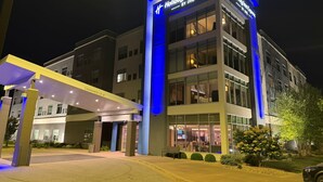 A Holiday Inn Express hotel with a modern facade, large windows, and a covered entrance area. - Holiday Inn Express Bettendorf Davenport NE by IHG (Bettendorf)