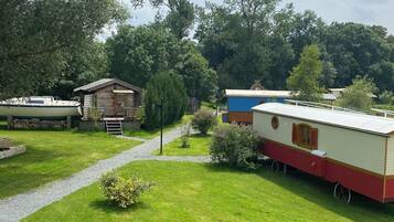 Un camping con casas móviles, un camino de grava y vegetación circundante.