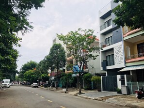 A street lined with multi-story residential buildings, some with balconies and potted plants. - Affordable and Quiet Studio near Dragon Bridge (Da Nang)