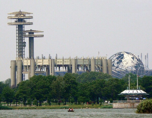 A large industrial structure with multiple cylindrical towers and a spherical building in the background. - Walk to the "U S OPEN"! (Queens)