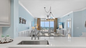 Una cocina moderna con una isla central, lavavajillas integrado y vistas al exterior.