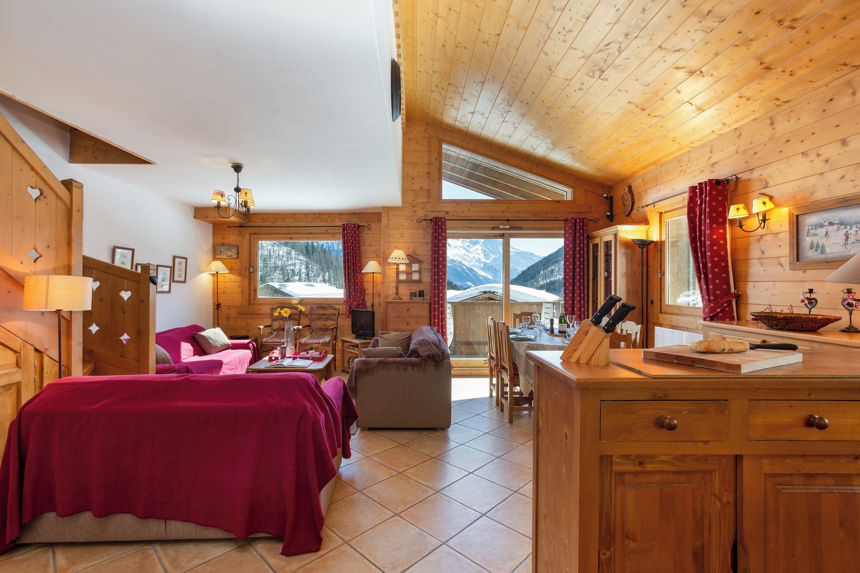 Ein gemütliches Blockhaus-Interieur mit Essbereich, einer Couch und einem Bett.
