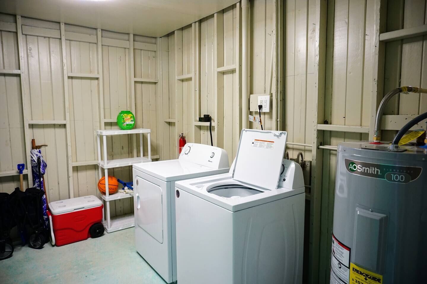 Een wasserette met een wasmachine, droger en een boiler.