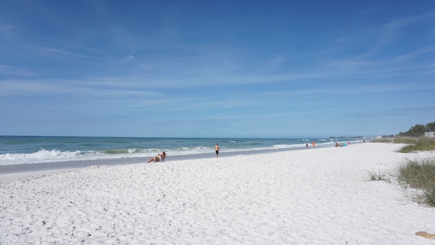 A wide sandy beach with a clear blue sky and calm sea. - Fall Specials Available! Pet Friendly! Steps to white sandy beaches and the bay!  Automatic discounts applied for stays longer than 7 days and 30 days! (Bradenton Beach)