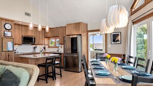 Una cocina moderna con armarios de madera, electrodomésticos de acero inoxidable e iluminación colgante.