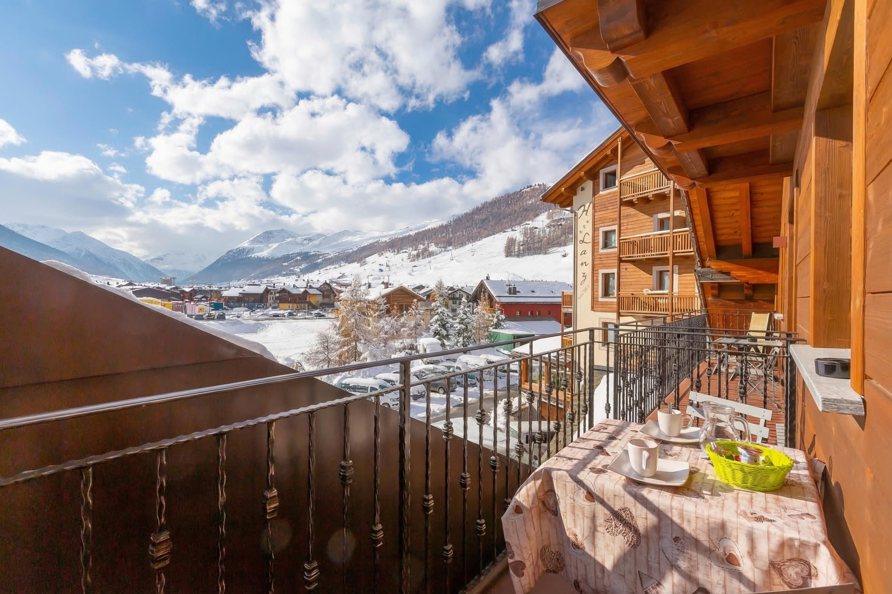 A wooden building with a balcony overlooking a snowy mountain landscape.