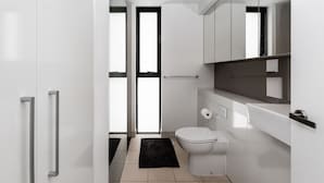 Une salle de bain moderne avec des toilettes, un lavabo et un miroir.