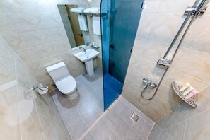 A bathroom with a toilet, sink, and shower area. - Hotel DK (Seogwipo)