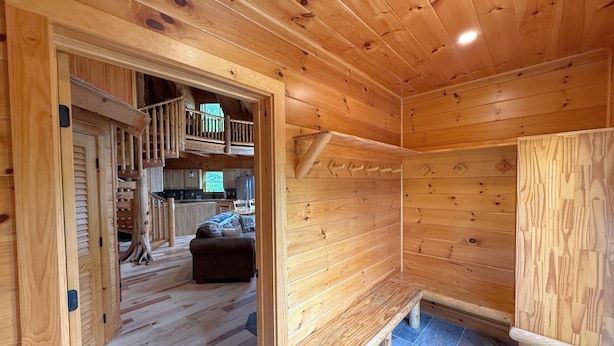 Un intérieur en bois comprenant un banc, un escalier et un coin cuisine.