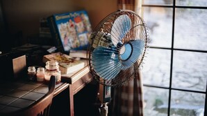 A fan in front of a window with a view of a stone path outside. - Deep Breath B&B (Shoufeng)