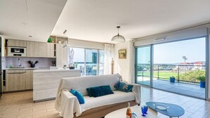 A modern apartment with a living area, kitchen, and balcony with a view. - Golfe Horizon by Interhome (Fréjus)