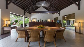 A spacious dining area with a large wooden table, wicker chairs, and a ceiling fan. - 3 Bedroom Balinese Style Villa, Lovely Villa Close to Shopping Area Seminyak (Seminyak)