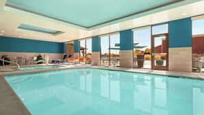 Une piscine dotée de chaises longues et offrant une vue sur l’extérieur.
