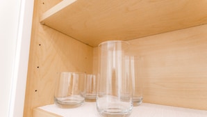 A wooden shelf with clear glassware.