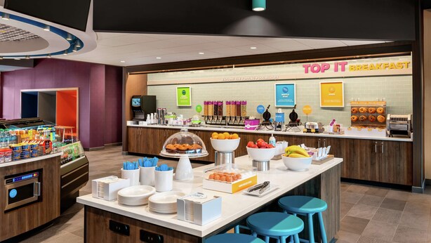 Zona de desayuno tipo buffet con diversas opciones de comida y una estación de café.