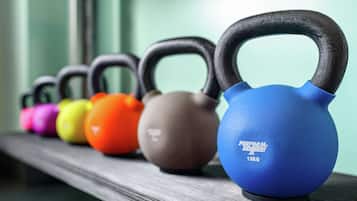 Un estante con varios kettlebells alineados.