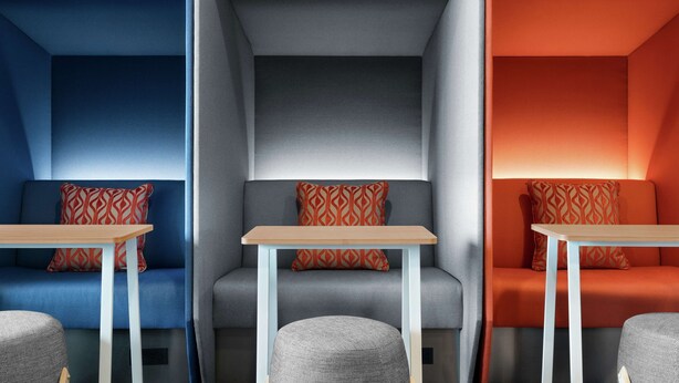 A modern interior with three distinct seating areas, each with a unique color scheme and patterned cushions. - Tru By Hilton Hershey Chocolate Avenue (Hershey)
