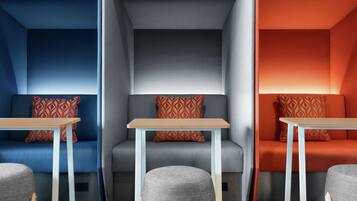 A modern interior with three distinct seating areas, each with a unique color scheme and patterned cushions.