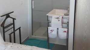 A compact bathroom with a shower, a small sink, and a towel rack. - Apartment with pool and magnificent views in the South of France (Saint-Chamas)