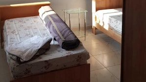 A bedroom with two beds, a small glass table, and giraffe decals on the wall. - Alburdini (Aqaba)