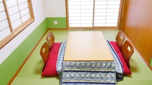 Perinteinen japanilainen huone, jossa on tatamimatto, matala puupöytä ja shoji-liukuovet.