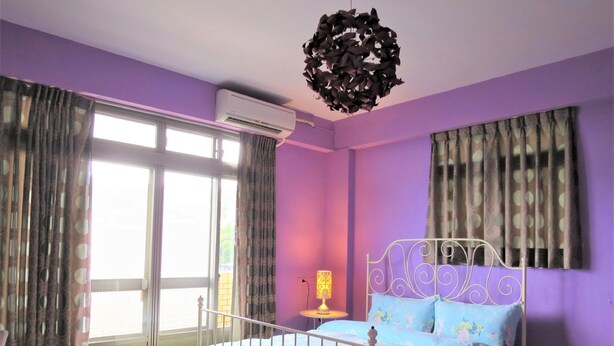 A bedroom with a bed, curtains, an air conditioning unit, and a hanging light fixture. - Hey Bear B&B Jiufen (New Taipei City)