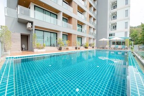 Una piscina al aire libre, tumbonas