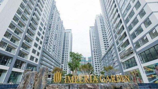 Un moderno grattacielo con un cartello ben visibile con la scritta "IMPERIA GARDEN".