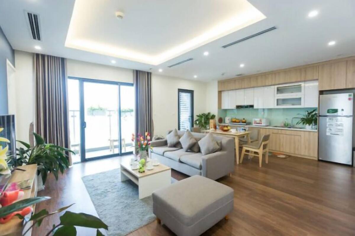 A modern apartment with a living room, kitchen, and dining area.