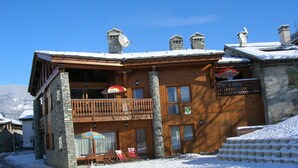 Un edificio in legno con un balcone, un cartello per un ristorante e vista sulle montagne.