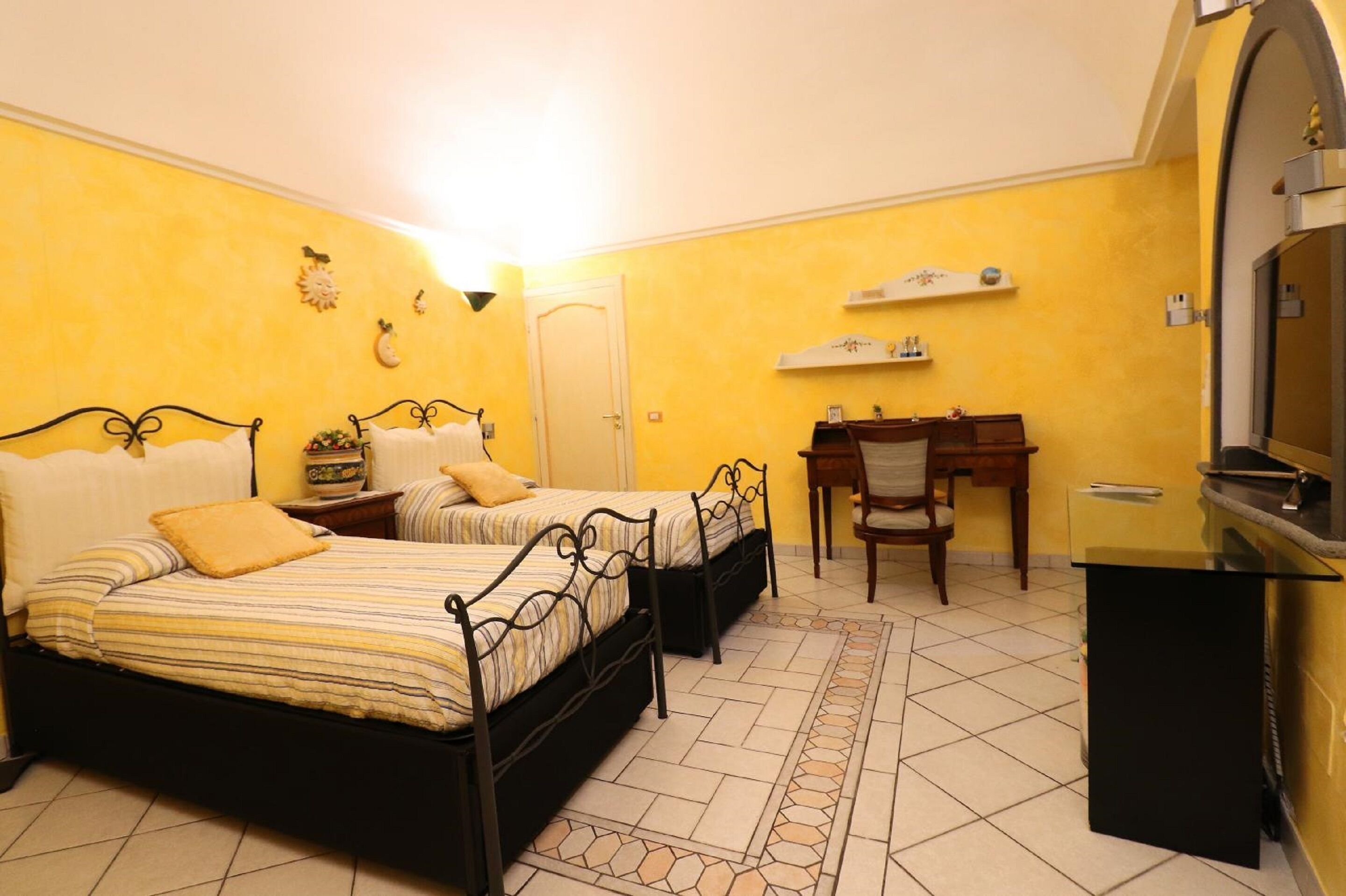 Une chambre avec deux lits, un bureau, une chaise et un téléviseur.