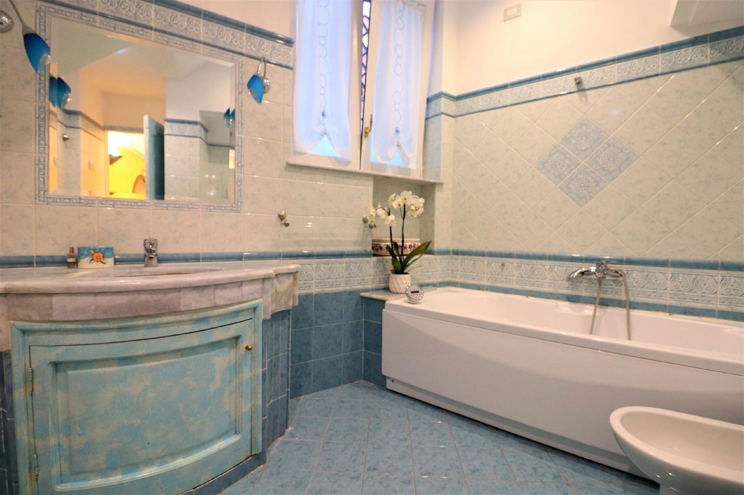 A bathroom with a bathtub, a sink, and a mirror.
