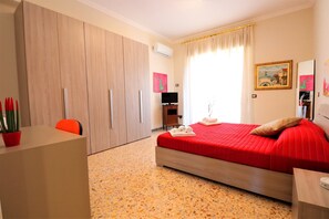 A hotel room with a bed, a desk, a chair, a wardrobe, and a TV. - Painter House (Sant'Agnello)
