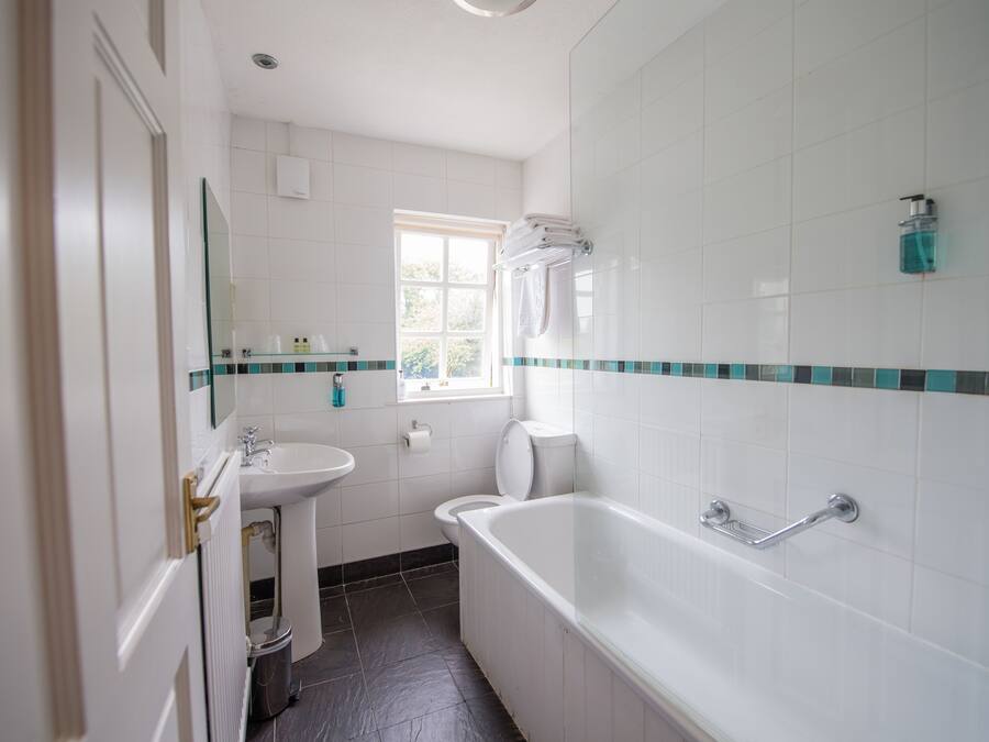 A bathroom with a bathtub, sink, and toilet.