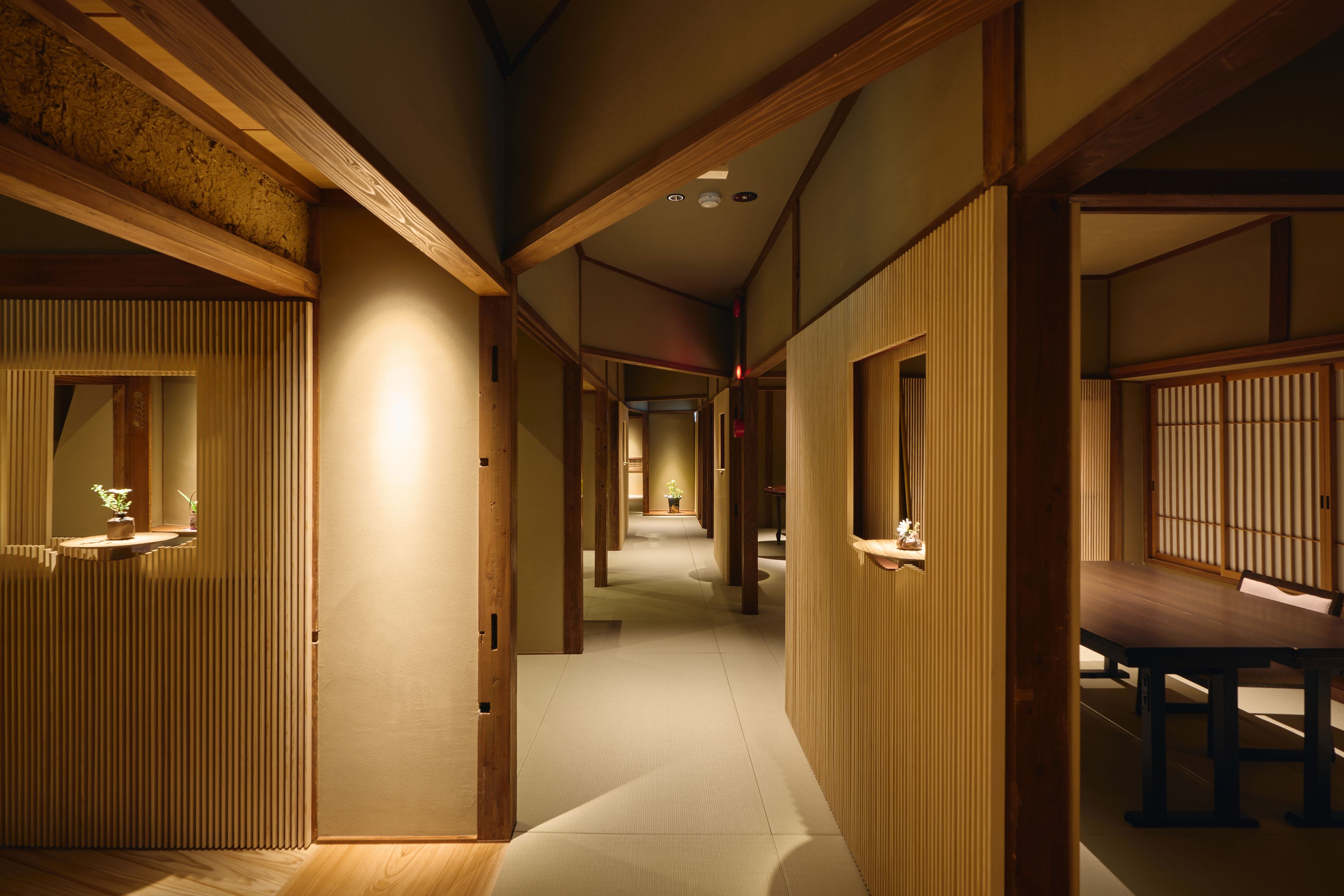 A traditional Japanese interior with tatami flooring, sliding doors, and a low ceiling.