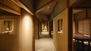 A traditional Japanese interior with tatami flooring, sliding doors, and a low ceiling.