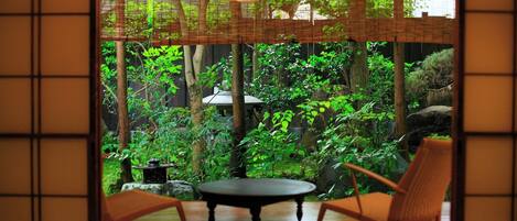 Una habitación con vistas a un jardín exuberante, una mesa y dos sillas.