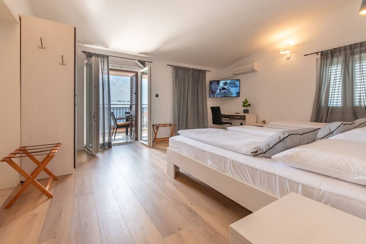 Una habitación de hotel moderna con una cama grande, un escritorio con computadora y televisión.