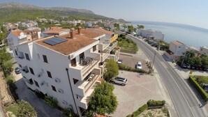 Un quartier résidentiel situé sur la côte, avec un imposant bâtiment blanc doté de balcons et d’une terrasse sur le toit.
