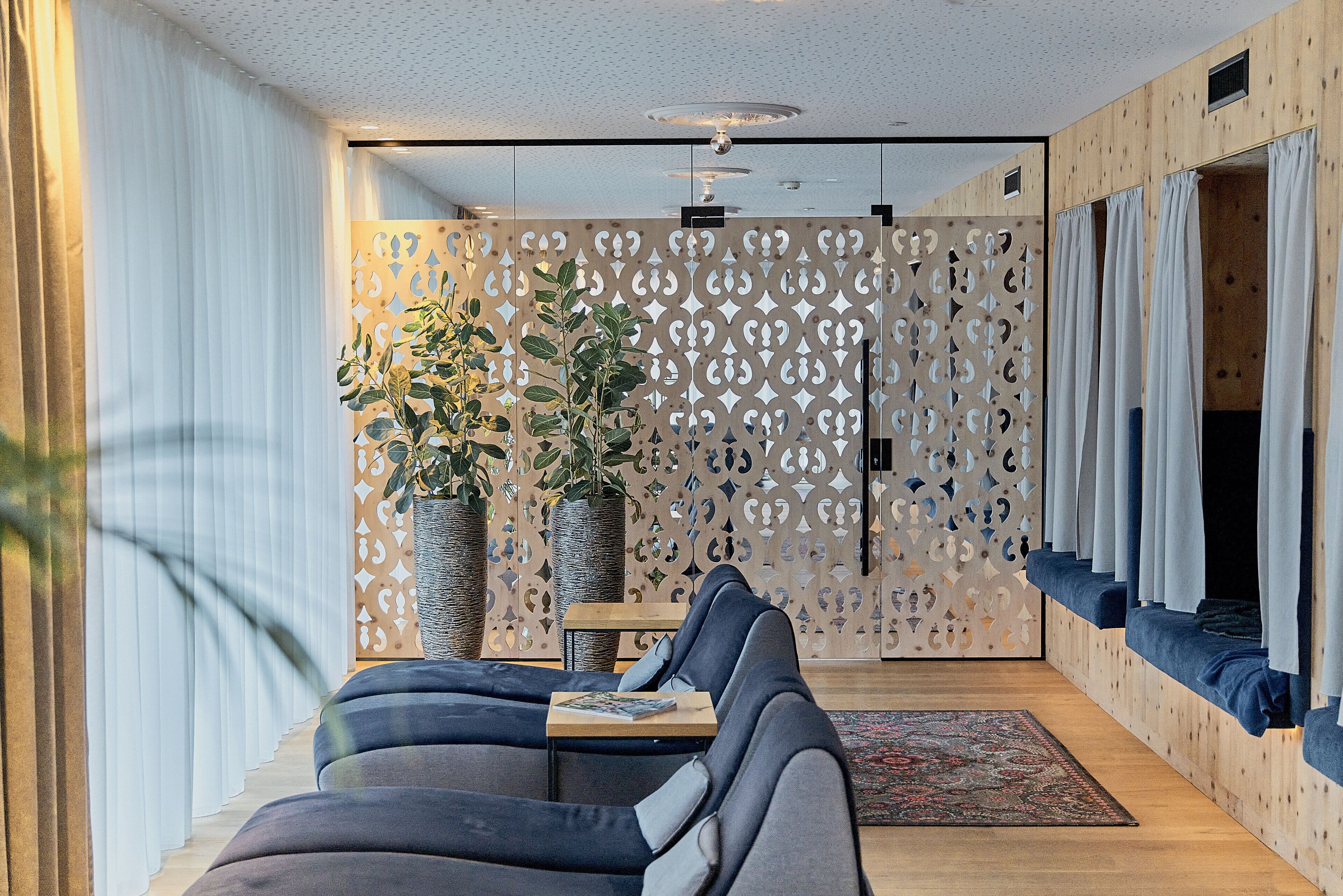 Ein modernes Wohnzimmer mit einer Couch, einem Couchtisch und einer Wand mit geometrischen Mustern.