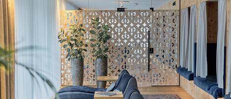 Ein modernes Wohnzimmer mit einer Couch, einem Couchtisch und einer Wand mit geometrischen Mustern.