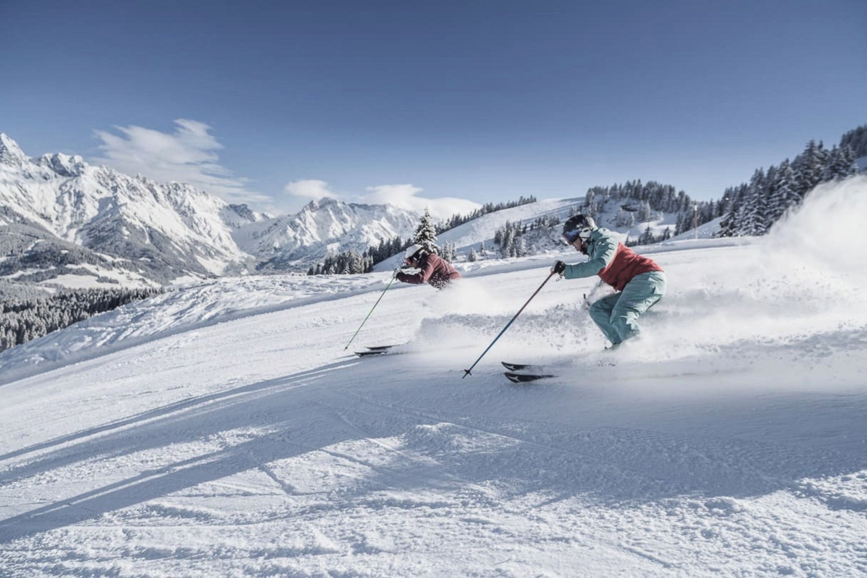 A snowy mountain landscape with skiers.